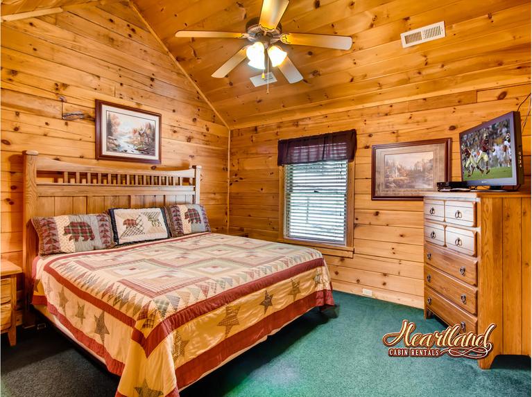 King size bed with ceiling fan and flat screen TV